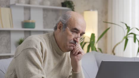 Thoughtful-old-man-at-laptop-dealing-with-financial-difficulties-while-paying-bills.